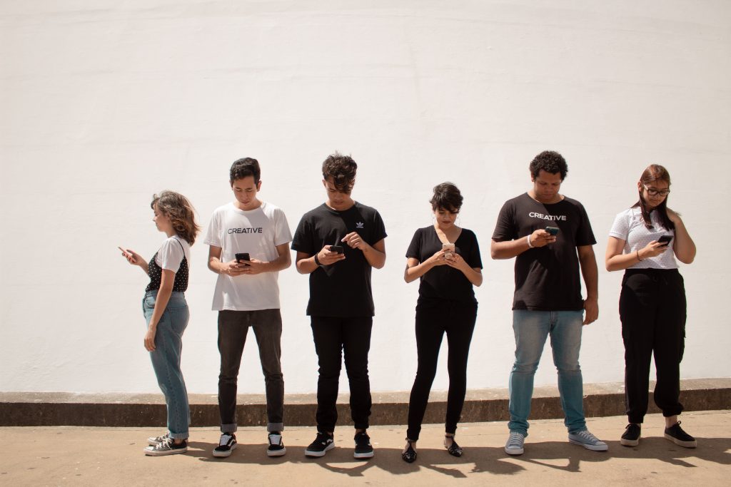 Image of teens in a line staring at their phones by Creative Christians on Unsplash