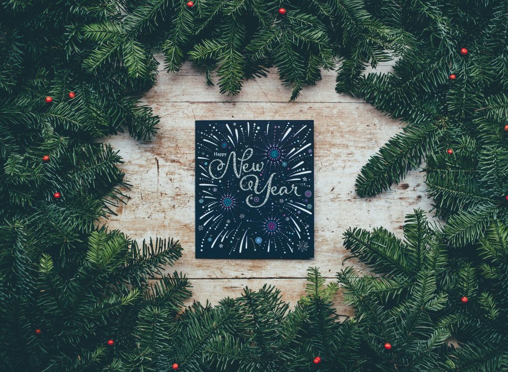 New Year's Eve Card with glittering fireworks surrounded by pine branches by Annie Spratt on Unsplash